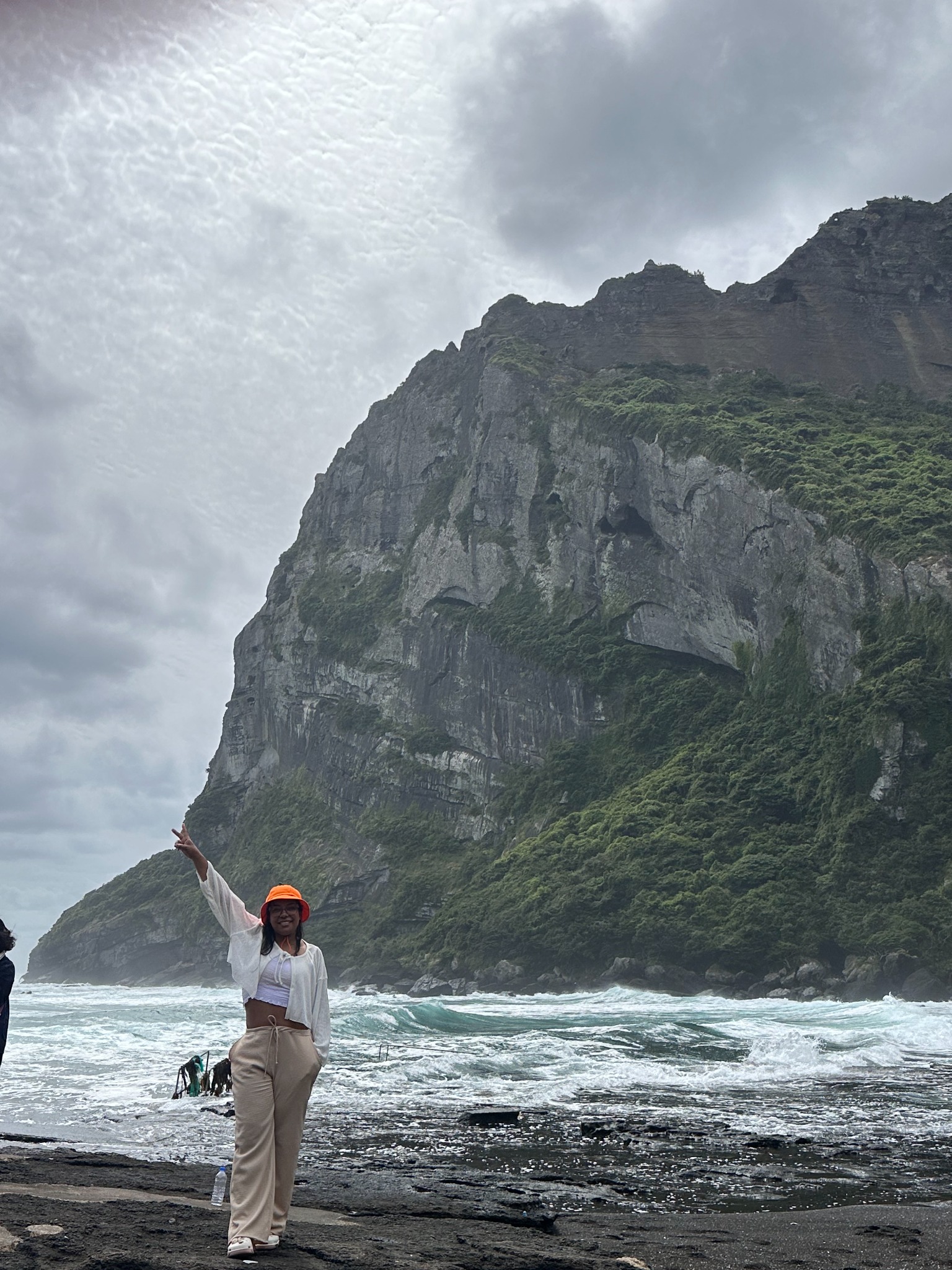 Viajante diante de uma grande falésia e do oceano no lado leste de Jeju